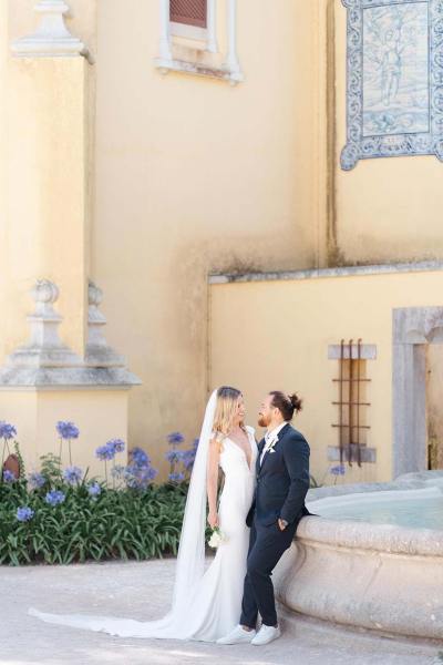 Bride and groom lean against wall to resort venue