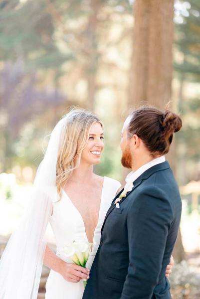 Bride and groom look at each other in forest park setting