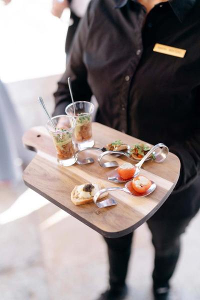 Fruit and crackers on wooden board served by waiter