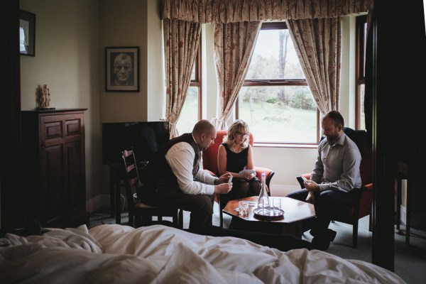 Groom groomsman and woman play cards