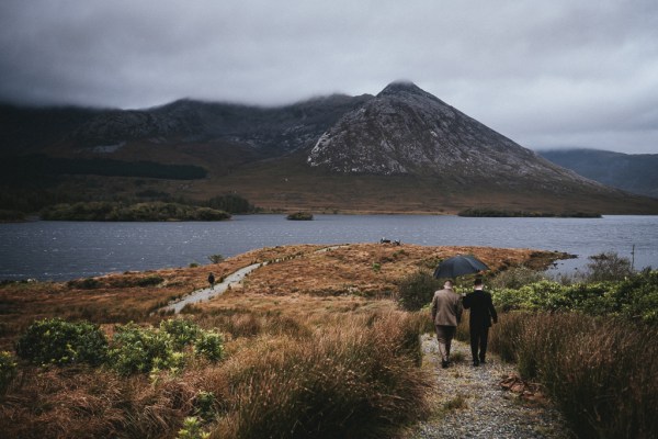 Guests walk downhill towards sea and mountains pathway