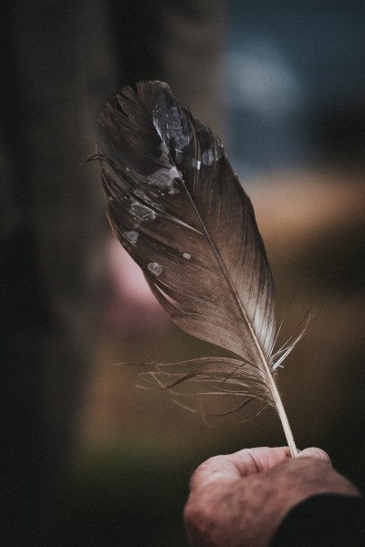 Celebrant holds feather in hand