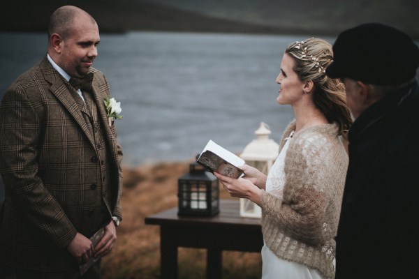 Bride reads her vows to groom lanterns in background