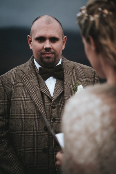 Groom watches as bride reads her vows to him