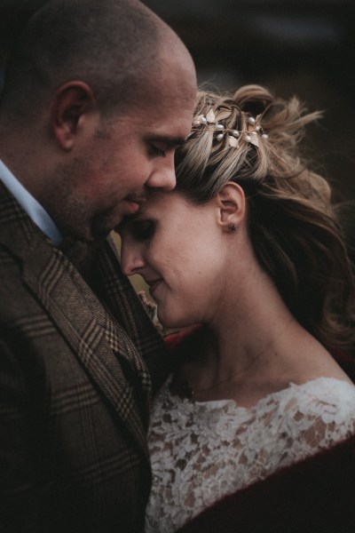 Bride places her head on grooms chest smiles