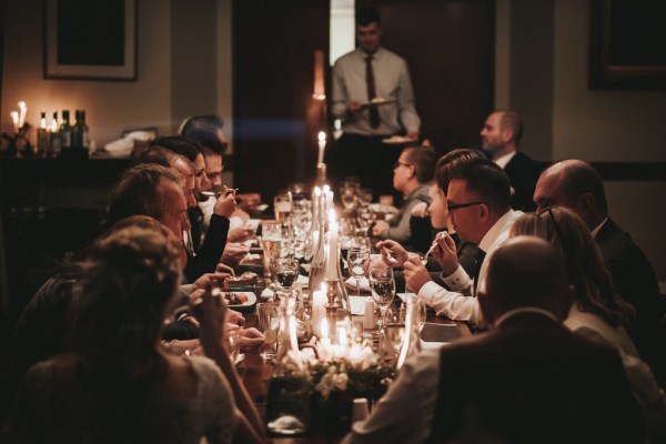 Bride groom and guests seated interior pub setting