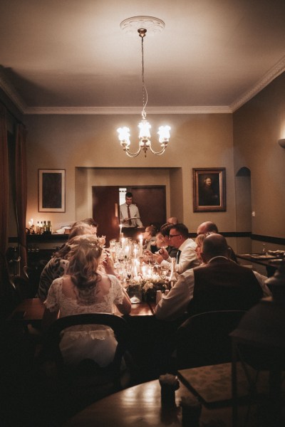 Bride groom and guests seated interior pub setting