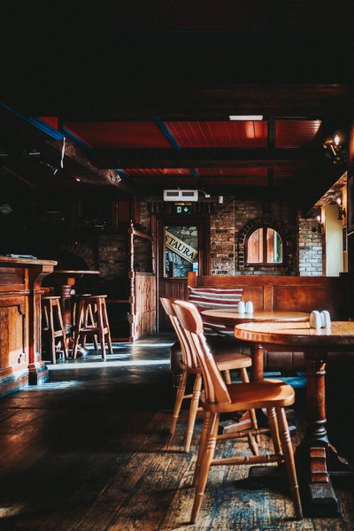 Empty pub showing wooden table and chairs interior