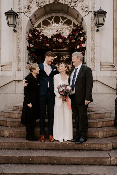 Bride groom mother and father on steps