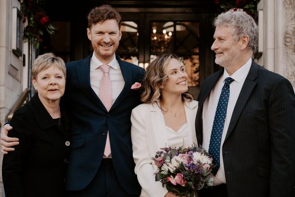 Bride groom mother and father all smiling