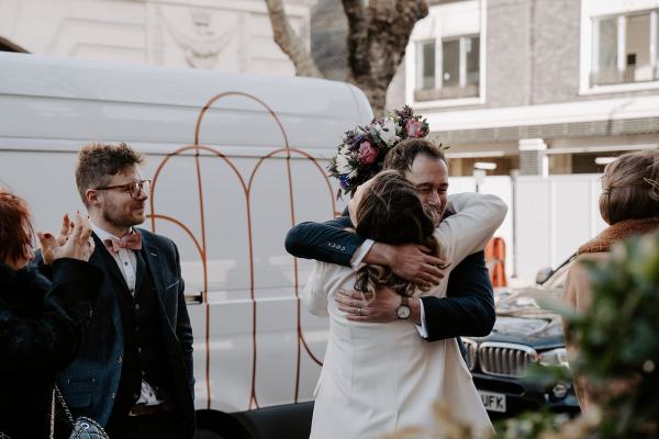 Bride hugs male guest