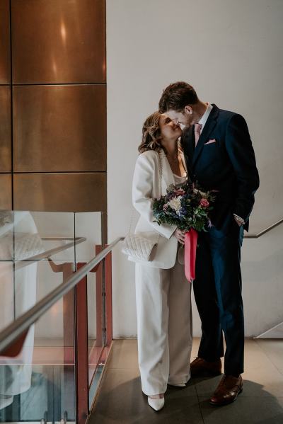 Bride and groom at top of stairs they kiss