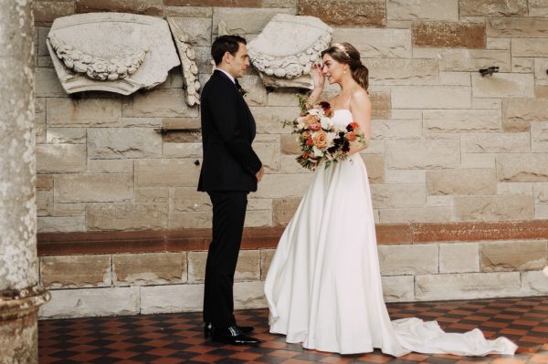 Groom laughs with bride as she holds bouquet bride gets emotional and cries