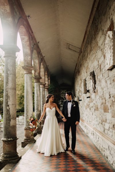 Bride and groom walking on tiles holding hands