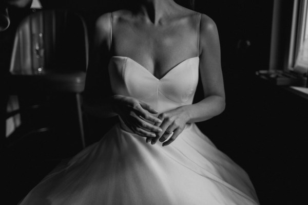 Bride cups hands black and white dress bridal gown shot