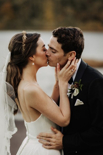 Up close view of bride and groom kissing she cups his face