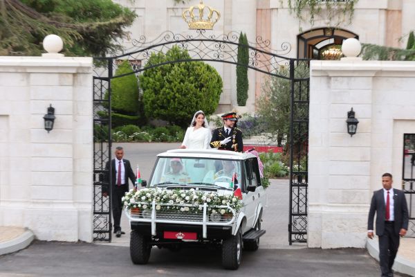 Jordan's Crown Prince Hussein (R) and his wife Saudi Rajwa al-Seif wave as they leave the Zahran Palace in Amman