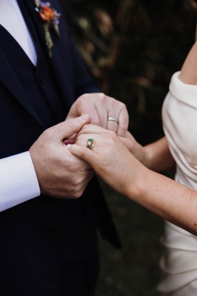 Bride and groom holding hands showing off wedding bands/rings