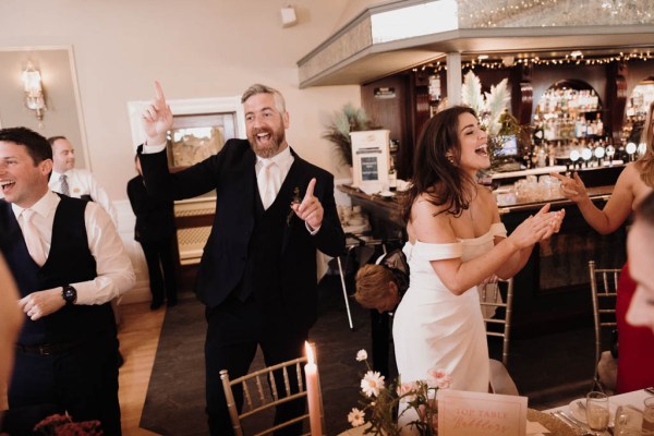 Bride and groom enter ballroom guests are cheering