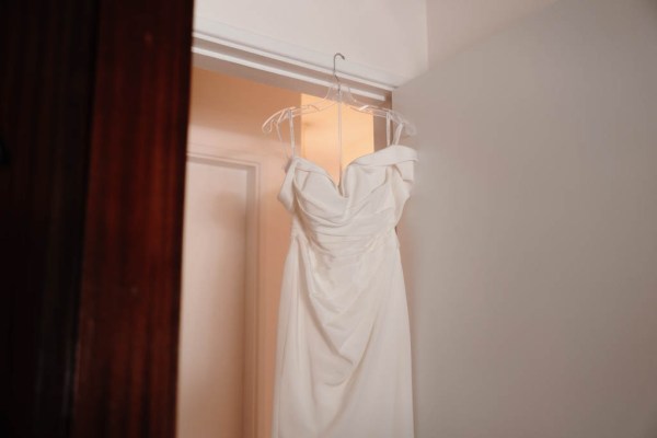 Wedding dress hanging at doorframe