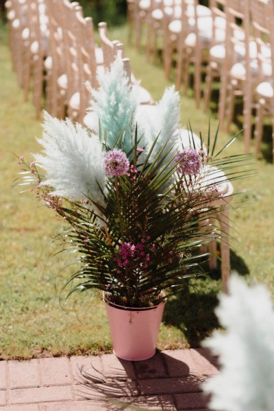 Shot of flowers in a vase grass and chairs in background