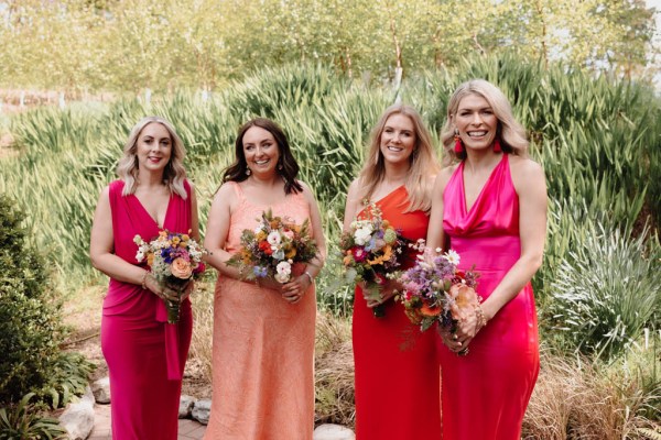 Four bridesmaids in orange/pink dresses