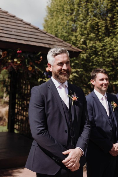 Groom stands at alter waiting for his bride