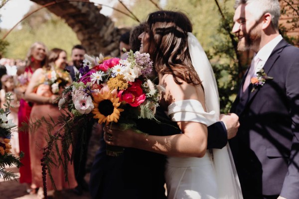 Family members hug the bride