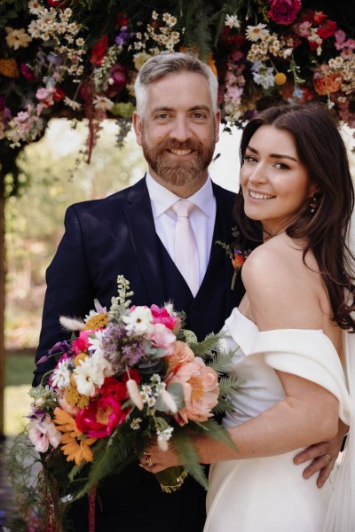 Bride and groom face the camera and smile