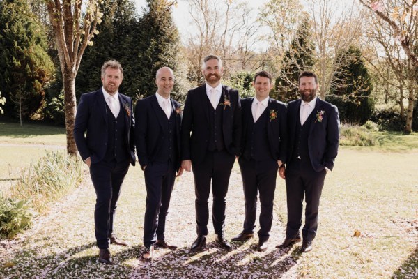 Groom and groomsmen on their own in forest garden