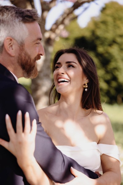 Bride and groom smiling laughing to each other