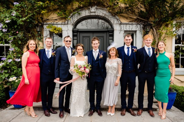 Family portrait photo of bride groom mother father groomsmen