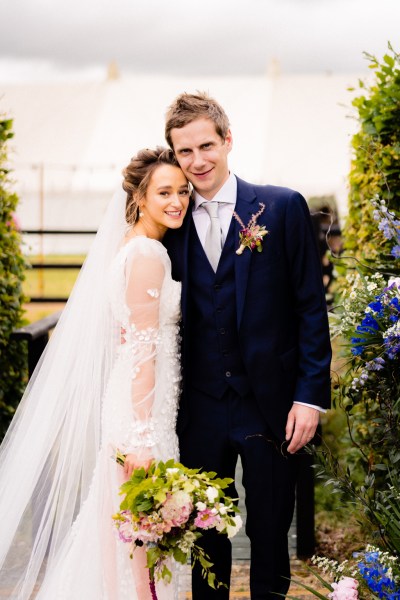 Bride and groom hug embrace fence farm garden scenery