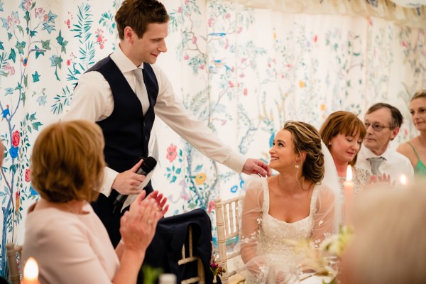 Groom gives speech bride laughs to audience and guest members