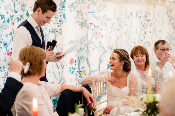 Groom gives speech bride laughs to audience and guest members