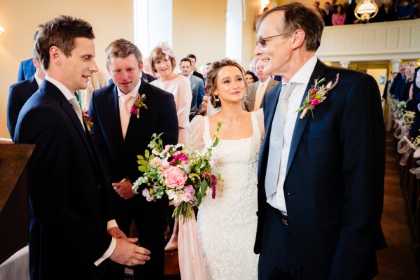 Father of the bride hands her over to groom at alter