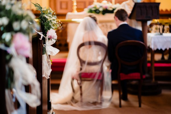 Blurry photo of bride and groom sitting beside alter