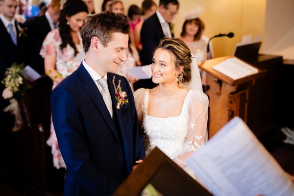 Bride and groom celebrant/priest smiling at each other