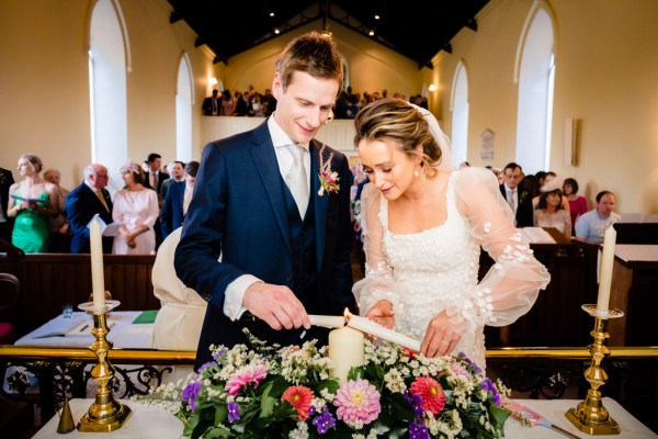 Bride and groom lighting the one candle on table