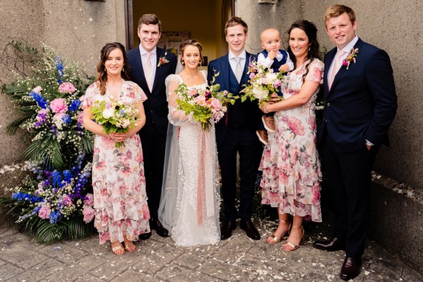 Family portrait bridesmaids groomsmen bride and groom and little baby in arms