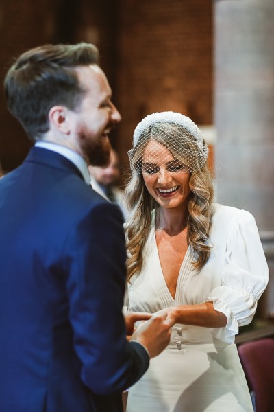 Bride and groom laugh together at alter