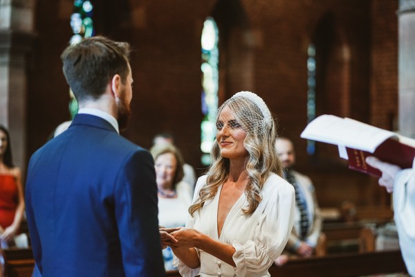 Bride reading her vows to groom and smiling