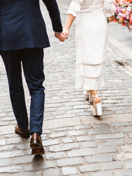 Bride and groom walking through Temple Bar bricked tiles