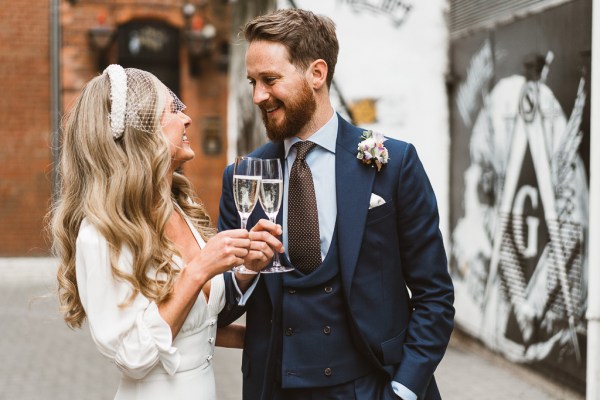 Bride and groom cheers with glasses of champagne/prosecco they look at each other