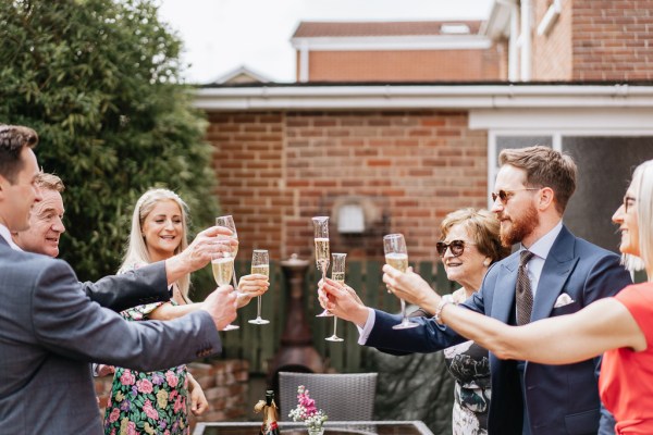 Groom family and friends cheers with glass of prosecco/champagne