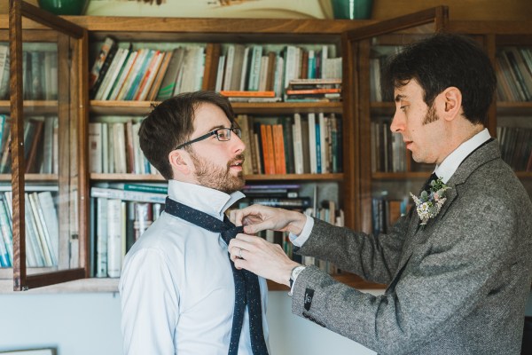 Groom and his groomsmen get ready together he gets help with his tie