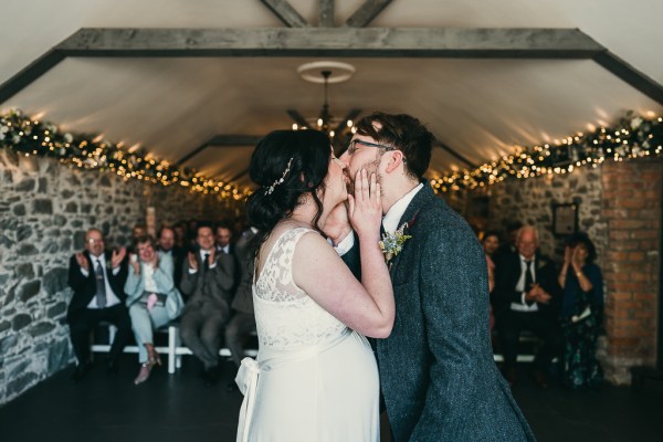 Bride and groom kiss at the alter