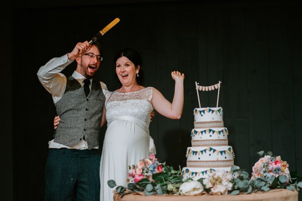 Bride and groom about to cut the white wedding cake