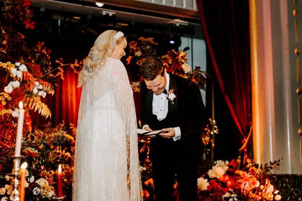 Bride and groom at alter confetti flowers drop on couple groom gives speech