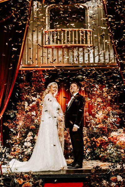 Bride and groom at alter confetti flowers drop on couple